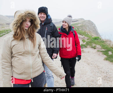 Famiglia in un abbigliamento caldo camminando sul percorso Foto Stock