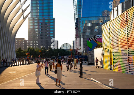 Un giovane modello nero pone per un fotografo a Fulton Street, Manhattan vicino alla Freedom Tower, al sole del tardo pomeriggio Foto Stock