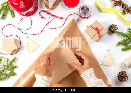 Regalo di natale di avvolgimento. Donna di mani Imballaggio regalo di Natale scatola in carta craft. Vista superiore Foto Stock