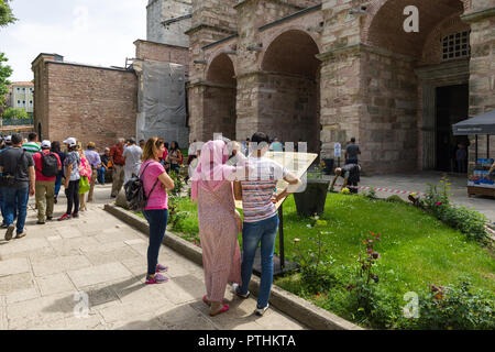 I turisti alla ricerca di una grande mappa dettagliata fuori l'ingresso mostra la chiave presenta e posizioni all'interno del Museo Hagia Sophia, Istanbul, Turchia Foto Stock