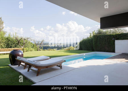 Piscina privata di fronte un appartamento con panchine e. sedie a sdraio Foto Stock