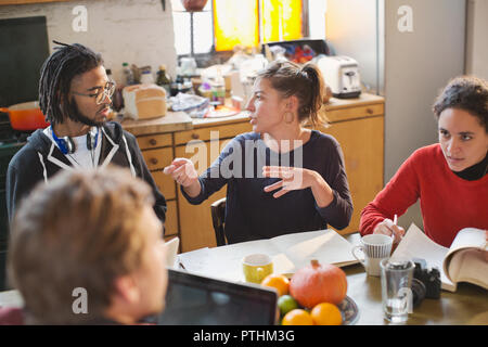 Giovane studente di college coinquilini studiando, parlando al tavolo da cucina in appartamento Foto Stock