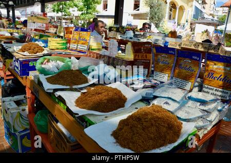 Il tabacco di antiquariato di frutta verdura bric comunista a brac e bandiere per la vendita nel pazari i ri market central Tirana Albania Foto Stock