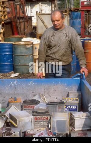 Discarica di relitti metallico nella periferia nord di Milano (Italia), la raccolta differenziata di auto usate batterie per essere digerito come rifiuti speciali Foto Stock
