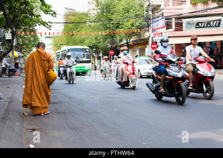 HO CHI MINH CITY - febbraio 5: Monk passeggiate a piedi nudi sulla strada trafficata il 5 febbraio 2012 nella città di Ho Chi Minh, Vietnam. Foto Stock