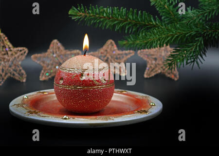 Candela che brucia con decorazione natalizia sullo sfondo Foto Stock