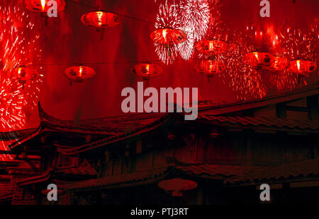 La celebrazione del Capodanno cinese cinese di tetti con lanterne in cielo e fuochi d'artificio con fumo rosso sfondo sorprendenti Foto Stock