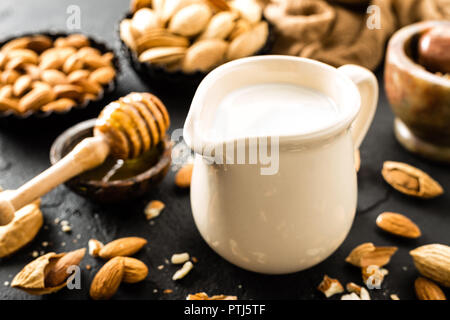 In casa latte di mandorla nella caraffa. Latte di mandorle e mandorle Foto Stock