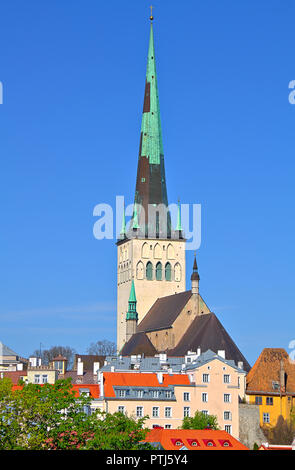 San dell'Olaf chiesa a Tallinn in Estonia. Sharp torre della chiesa con la calma di un cielo estivo blu sullo sfondo. Alcuni edifici colorati in foregroun Foto Stock