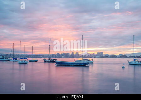 Porto di San Diego, San Diego, California, USA. Barche ormeggiate nel porto durante una torbida sunrise. Foto Stock