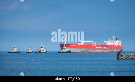 Il grezzo petroliera Mar Egeo potenza viene portato nella guarnizione Sands port da quattro rimorchiatori. Foto Stock