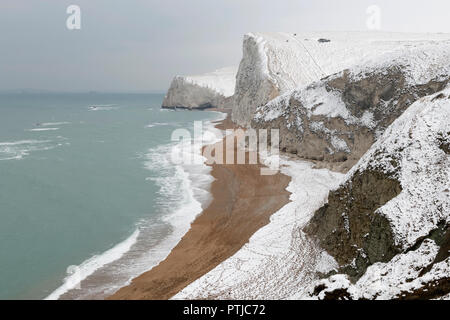 Bat la testa sotto la neve su la costa del Dorset. Foto Stock