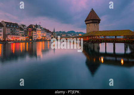 Il Kapellbrücke (Ponte della Cappella) è ricoperta di una passerella in legno che attraversano diagonalmente attraverso il Fiume Reuss nella città di Lucerna in Svizzera centrale. Foto Stock