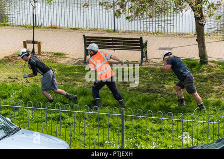 A sud ovest di lavoratori di elettricità tira un cavo in posizione. Foto Stock