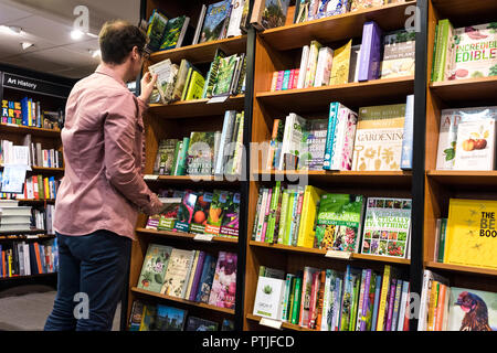 Un uomo navigando in un Waterstones book shop. Foto Stock