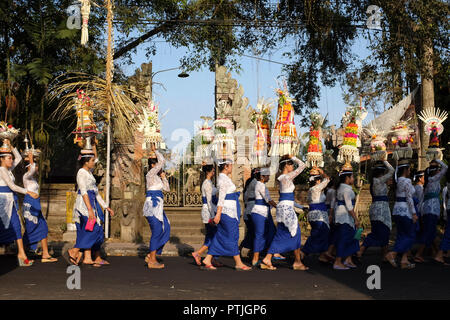 Donna Balinese in abbigliamento tradizionale durante una processione religiosa sulla strada. Foto Stock