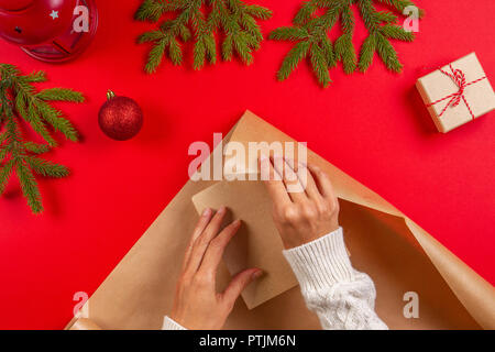 Regalo di natale di avvolgimento. Donna di mani Imballaggio regalo di Natale scatola in carta craft. Foto Stock