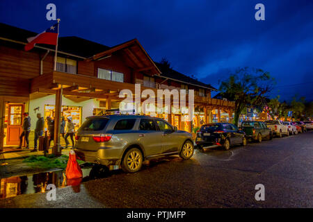 PUCON, Cile - SETTEMBRE, 23, 2018: veduta esterna di automobili parcheggiate in una fila per le strade della città in Pucon di notte Foto Stock