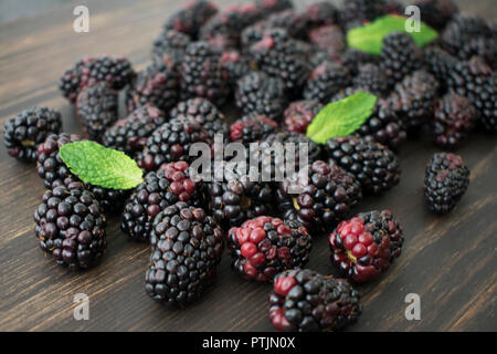 More di rovo e foglie di menta sparsi su un tagliere Foto Stock