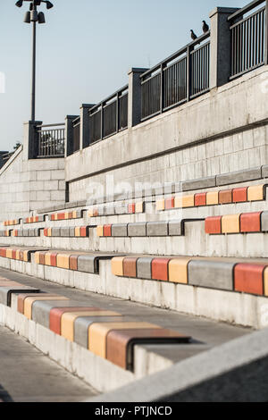 File di sedili colorati in strada Foto Stock