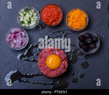 Tartare di manzo con un uovo su ardesia Foto Stock