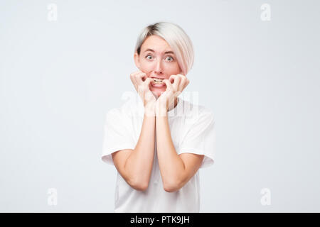 Ritratto di preoccupato paura donna con la tintura dei capelli corti guardando la telecamera, studio shot. Foto Stock