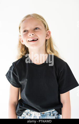 Ritratto di adorabile bambino felice in black t-shirt ridendo e guardando lontano isolato su bianco Foto Stock