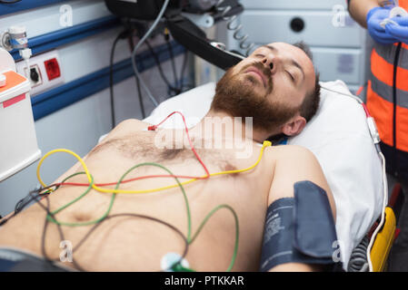 Elettrodi ECG sul torace del paziente in ambulanza Foto Stock