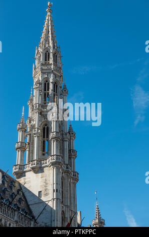 Bruxelles, Belgio - 26 Settembre 2018: la guglia e la facciata di pietra grigia municipio con statue e contro il cielo blu. Foto Stock