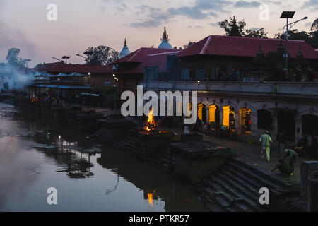 Kathmandu, Nepal - Ott 8,2018:Indù i rituali di cremazione presso le rive del fiume Bagmati al tempio di Pashupatinath locali Aryaghat , Kathmandu. Foto Stock