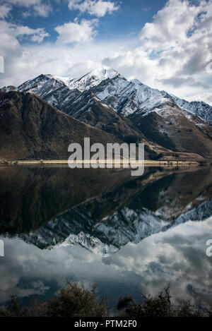 Montagne coperte di neve nei pressi di Ben Lomond riflettere nello specchio come fuma vicino Lago Queenstown in Nuova Zelanda. Foto Stock