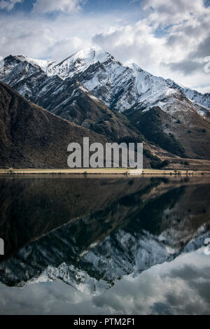 Montagne coperte di neve nei pressi di Ben Lomond riflettere nello specchio come fuma vicino Lago Queenstown in Nuova Zelanda. Foto Stock