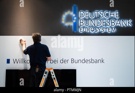 09 ottobre 2018, Assia, Frankfurt principale: un uomo utilizza un panno per pulire la Deutsche Bundesbank dello stand alla fiera del libro di Francoforte. Il più grande del mondo mostra del libro si svolge dal 10 al 14 Ottobre. Foto: Sila Stein/dpa Foto Stock