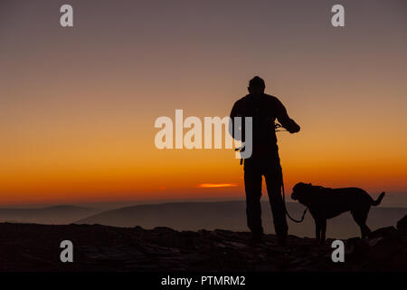 Pen y ventola, Brecon Beacons, Wales, Regno Unito. Il 10 ottobre 2018. Hill walkers godono di una drammatica sunrise dal picco del Pen y Fan, la montagna più alta nel sud della Gran Bretagna si trova in Brecon Beacons. Su ciò che è previsto per essere una calda e luminosa giornata autunnale con temperature in Galles del Sud previsto a picco su 21gradi celsius. Credito: Haydn Denman/Alamy Live News Foto Stock