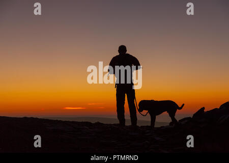 Pen y ventola, Brecon Beacons, Wales, Regno Unito. Il 10 ottobre 2018. Hill walkers godono di una drammatica sunrise dal picco del Pen y Fan, la montagna più alta nel sud della Gran Bretagna si trova in Brecon Beacons. Su ciò che è previsto per essere una calda e luminosa giornata autunnale con temperature in Galles del Sud previsto a picco su 21gradi celsius. Credito: Haydn Denman/Alamy Live News Foto Stock