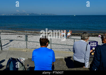 Brixham Devon. 10 ott 2018. Regno Unito Meteo,calda giornata di ottobre. Brixham gente sulla spiaggia di fronte a marina nel pomeriggio Robert Timoney/Alamy/Live/News Credit: Robert Timoney/Alamy Live News Foto Stock