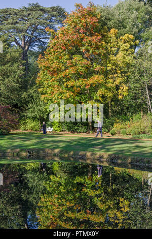 La Swiss Garden, Old Warden, Bedfordshire, Regno Unito. Il 10 ottobre 2018. Su un altro unseasonably warm giorno i visitatori al giardino godetevi i primi segni di colore di autunno si riflette nel lago. Credito: David Humphreys/Alamy Live News Foto Stock