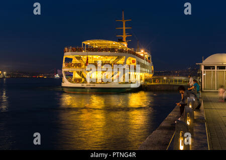 Un grande traghetto passeggeri attende presso il molo Eminonu al crepuscolo, Istanbul, Turchia Foto Stock