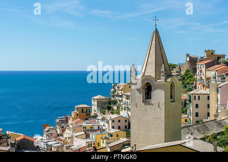 Vista del villaggio sul mare di Riomaggiore e la chiesa di San Giovanni Battista, Cinque Terre Liguria, Italia Foto Stock