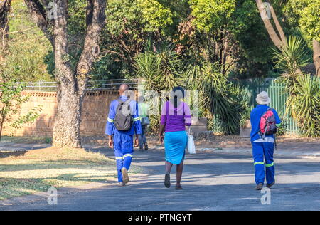 Johannesburg, Sud Africa - nero non identificato di persone a piedi per i loro posti di lavoro attraverso le strade di un sobborgo residenziale di immagine con spazio di copia Foto Stock