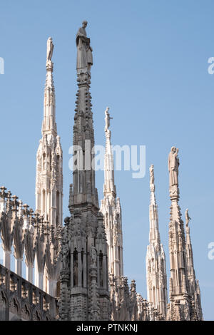 Foto scattata in alto sulle terrazze del Duomo di Milano / Duomo di Milano, Italia, mostra l'architettura gotica in dettaglio contro un cielo blu chiaro. Foto Stock