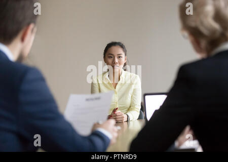 Asian richiedente talk durante il colloquio con reclutatori Foto Stock