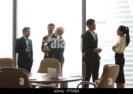 I colleghi avente casual parlare durante la pausa di lavoro in ufficio Foto Stock