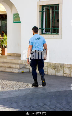 28 settembre 2018 un'armata nazionale portoghese poliziotto di guardia tornando alla stazione locale nella Città Vecchia Albuferia Foto Stock