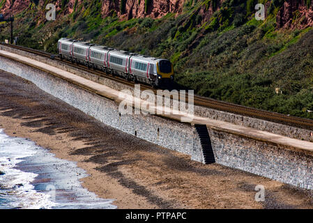 DAWLISH, Devon, Regno Unito - 3OCT2018: Arriva il Cross Country 220 Classe Treno ad Alta Velocità che viaggiano a nord lungo la parete del mare a Dawlish. Il Langstone roccia possono Foto Stock