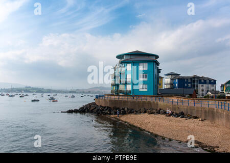 EXMOUTH, Devon, Regno Unito - 05Oct2018: piccola spiaggia accanto all'ingresso a Exmouth Docks con distintivi colorati edifici residenziali in Shelly behi su strada Foto Stock