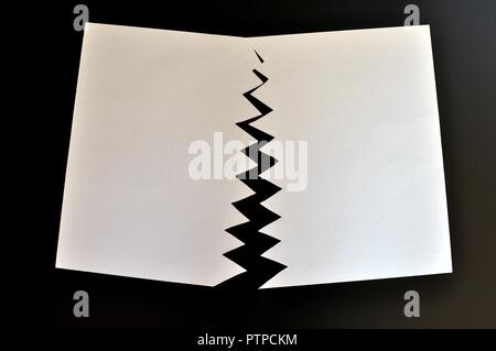 Concetto di diviso o separato carta strappata in due fogli. Libro bianco strappato a metà isolato su sfondo nero. Vista superiore Foto Stock