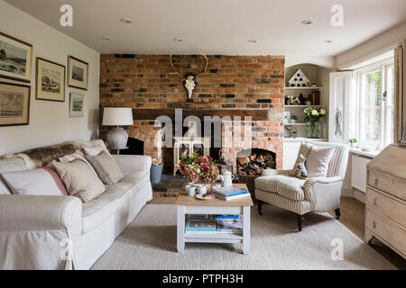 Illustrazione incorniciata sopra un divano con ovory woodburner nel XVIII secolo Norfolk cottage Foto Stock