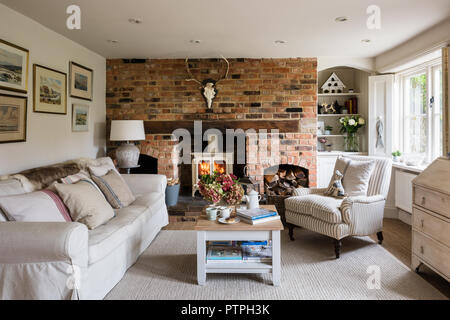 Illustrazione incorniciata sopra un divano con ovory woodburner nel XVIII secolo Norfolk cottage Foto Stock