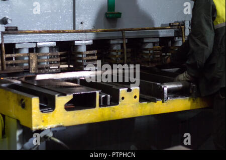 Il lavoratore è impegnato nel taglio di metallo sulla produzione macchina utensile automatica, il taglio del metallo, close-up Foto Stock